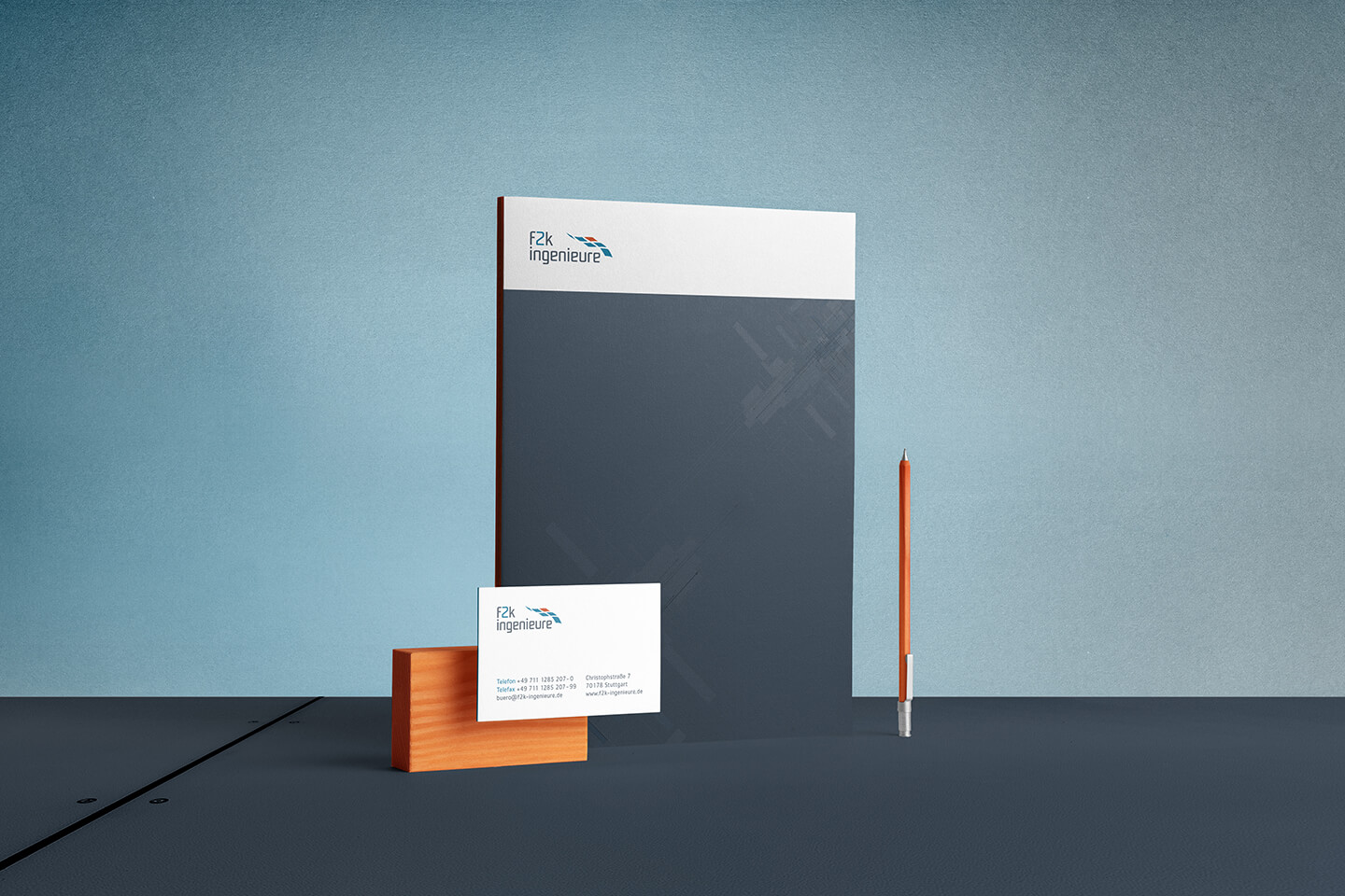Geschäftsausstattung von f2k ingenieure mit Briefpapier, Visitenkarte und orangefarbenem Bleistift.